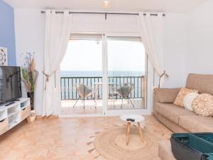 a living room with a couch and a view of the ocean at Apartamentos El Calón Playa in Cuevas del Almanzora