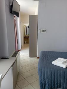um quarto com uma cama e uma cozinha com uma televisão em Camere Girasole em Lazise