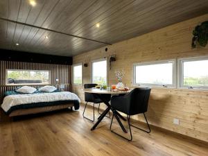 Schlafzimmer mit einem Bett und einem Tisch mit Stühlen in der Unterkunft La Cabane D'Emma Spa&Sauna privé in Bannalec