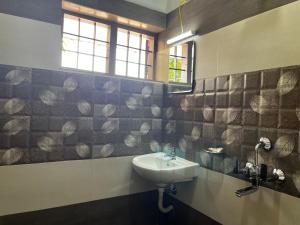 a bathroom with a sink and a window at Paddy N Canal Homestay in Alleppey