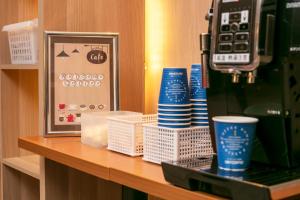 a counter with cups and a coffee machine at Smile Hotel Premium Sapporo Susukino in Sapporo