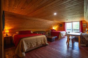 サン・マチュー・デュ・パルクにあるL'Auberge Refuge du Trappeurの木製の部屋にベッド2台が備わるベッドルーム1室