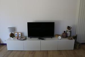 a flat screen tv sitting on top of a white cabinet at Studio charmant au calme in Aix-en-Provence +23 photos