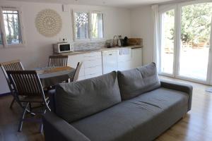 a living room with a couch and a table at Studio charmant au calme in Aix-en-Provence