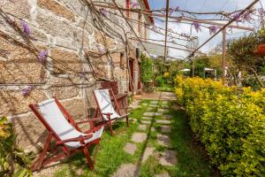 twee stoelen in het gras in een tuin bij Casa da Benfeitoria in Guimarães