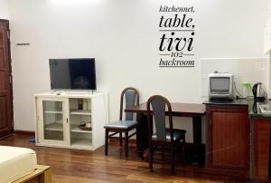 - un salon avec une table, des chaises et une télévision dans l'établissement Riverhome Saigon Apartments, à Hô-Chi-Minh-Ville