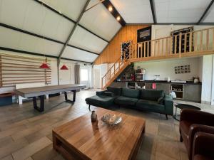 a living room with a ping pong table and a couch at Aldörrum Hoevelogementen in Aarle-Rixtel