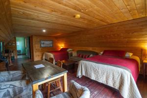 una camera da letto in legno con 2 letti e un divano di L'Auberge Refuge du Trappeur a Saint Mathieu Du Parc