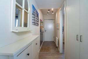 un corridoio con pareti bianche, un bancone bianco e una porta di Haus-Ostseeapartments-am-Fehmarnsund-Wohnung-27-Strandrubin a Grossenbrode Altre 14 foto