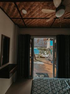 a bedroom with a ceiling fan and a view of the ocean at Gloria's Beach House in Oslob
