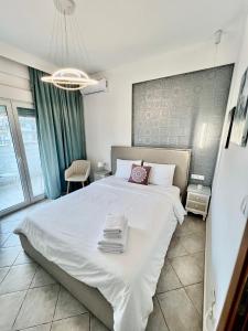 a bedroom with a large bed with towels on it at City lux apartment 2 in Serres
