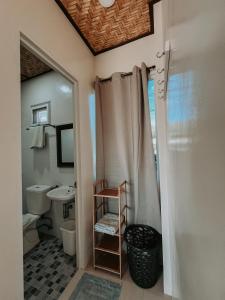 a bathroom with a shower curtain and a sink at Gloria's Beach House in Oslob
