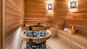 a sauna with a circular tub in a wooden wall at Black Sea Luxury Apartment in Batumi