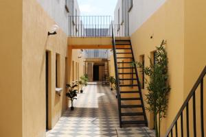 an internal corridor of a building with stairs and plants at WUER Arco de la Calzada in León +56 photos