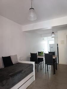 ein Wohnzimmer mit einem Sofa, einem Tisch und Stühlen in der Unterkunft Shanti Alojamiento Monoambiente y Departamento in Mendoza