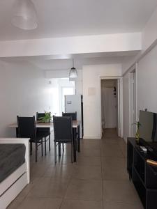 cocina y comedor con mesa y sillas en Shanti Alojamiento Monoambiente y Departamento en Mendoza