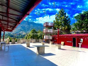 a patio with tables and chairs and a red building at Hotel Shiva Lake Mussoorie - 360 Degree View - Free Parking in Mussoorie