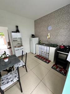 a kitchen with white appliances and a table in it at Casa Maresia in Saquarema