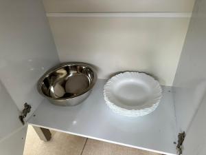 a bowl and a plate on a shelf in a cabinet at Casa Maresia in Saquarema +9 photos
