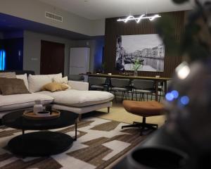 Urban Heaven, Luxury Hostel - JBR - Walk To Beach, Metro Station في دبي: غرفة معيشة مع أريكة بيضاء وبار