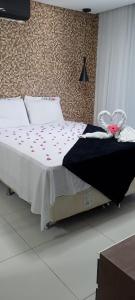 - une chambre avec un lit orné de fleurs roses dans l'établissement Pratagy quarto/sala superior, à Maceió