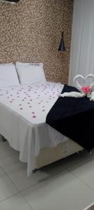 - un lit avec une couette en noir et blanc et une arche rose dans l'établissement Pratagy quarto/sala superior, à Maceió