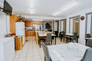 cocina y comedor con mesa y sillas en Mosaic Suites, en Red Deer