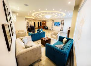 a living room with blue couches and a ceiling at Petra Premium Hotel in Wadi Musa