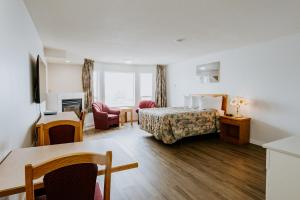 um quarto de hotel com uma cama e uma secretária em Mosaic Suites em Red Deer