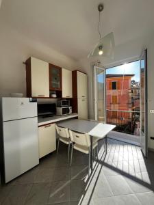 une cuisine avec une table et un réfrigérateur blanc dans l'établissement Sant'Andrea Appartamento nel borgo antico, à Levanto 4 autres photos