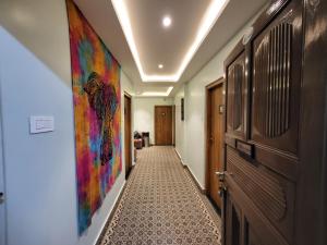 a hallway with a colorful painting on the wall at The Revett in Darjeeling