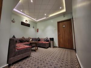 a waiting room with couches and a table and a door at The Revett in Darjeeling