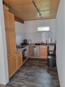 a small kitchen with wooden cabinets and a window at Haus Ziegenblick in Herbolzheim