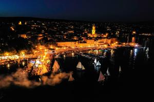 a city lit up at night with boats in the water at Apartments Sinisa - Krk Town in Krk