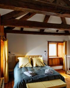 a bedroom with a bed with blue sheets and a window at La ch'tiote meizou in Mazet-Saint-Voy