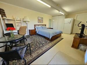 a bedroom with a bed and a table and a kitchen at Cosy Unit at Modbury in Modbury