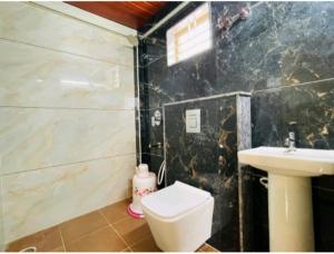 uma casa de banho com um WC e um lavatório em Yashaswiny recidency em Mysore