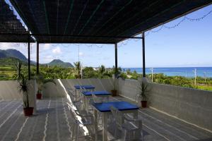 a patio with tables and chairs and the ocean at The Blue Lagoon B&B in Fengbin