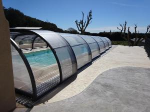 um edifício de metal curvo com piscina em gite la bonnelle piscine spa em Grillon