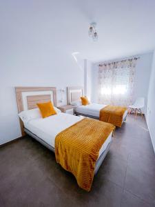 1 dormitorio con 2 camas con mantas de naranja en Modern Three bed Apartment, en San Pedro del Pinatar