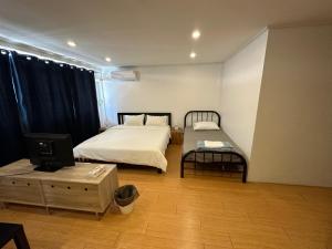 1 dormitorio con 1 cama, TV y mesa en The Cute Silom hostel, en Bangkok