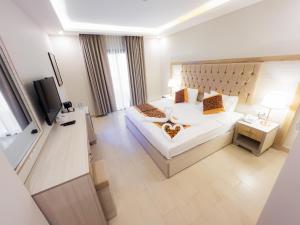 Petra Premium Hotel في وادي موسى: غرفه فندقيه سرير كبير وتلفزيون