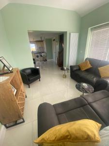 ein Wohnzimmer mit einem schwarzen Sofa und einem Tisch in der Unterkunft Ceecliff flat in Culdaff