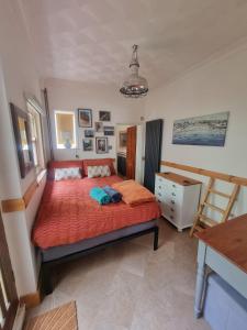a bedroom with a large bed with a red bedspread at Shore Thing - Just a stones throw from the beach in Sandgate