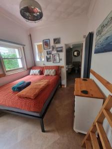 a bedroom with a bed and a wooden table at Shore Thing - Just a stones throw from the beach in Sandgate