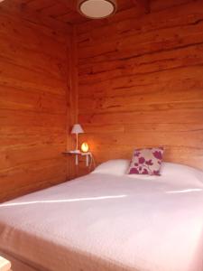 una camera con un letto in una baita di tronchi di Cabaña El Cardenal a Tandil