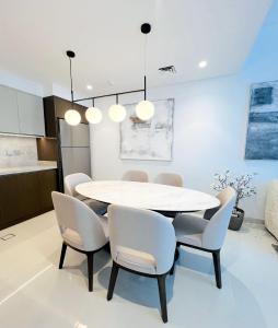 ドバイにあるSea Breeze Oasisの白いテーブルと椅子のあるダイニングルーム