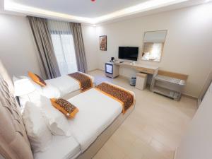 a hotel room with two beds and a television at Petra Premium Hotel in Wadi Musa