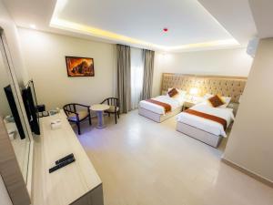 Petra Premium Hotel في وادي موسى: غرفة فندقية بسريرين وطاولة