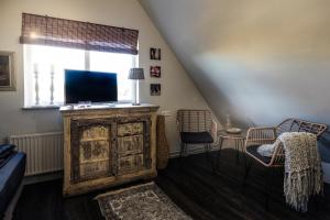 een woonkamer met een tv en een raam bij Bed and Relax Terschelling in Midsland